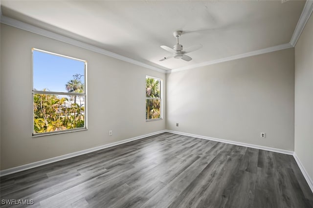 spare room with ornamental molding, dark wood-type flooring, baseboards, and a ceiling fan