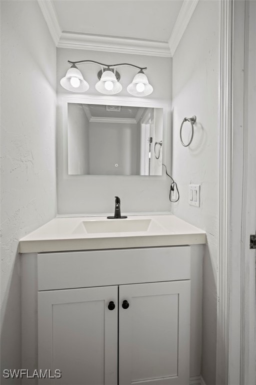 bathroom featuring a textured wall, ornamental molding, and vanity