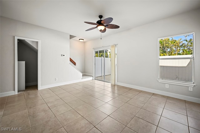 tiled spare room featuring ceiling fan and baseboards