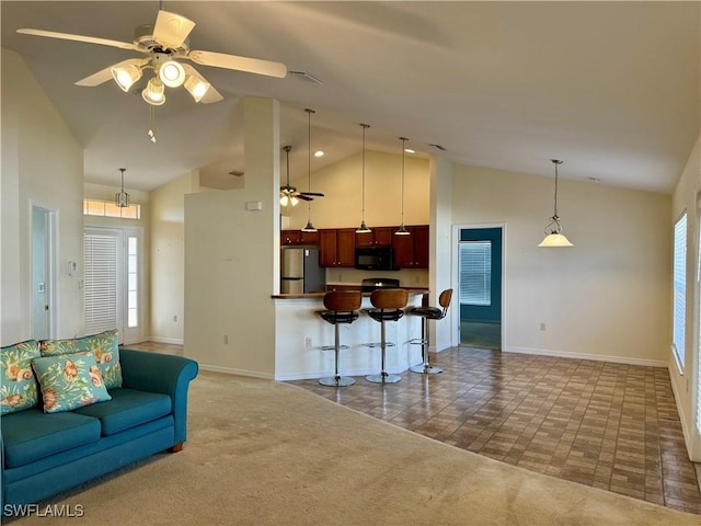 kitchen featuring carpet floors, freestanding refrigerator, open floor plan, ceiling fan, and black microwave