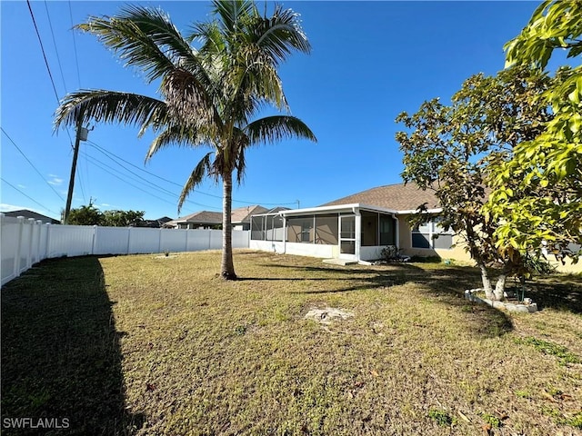 view of yard with a sunroom and a fenced backyard