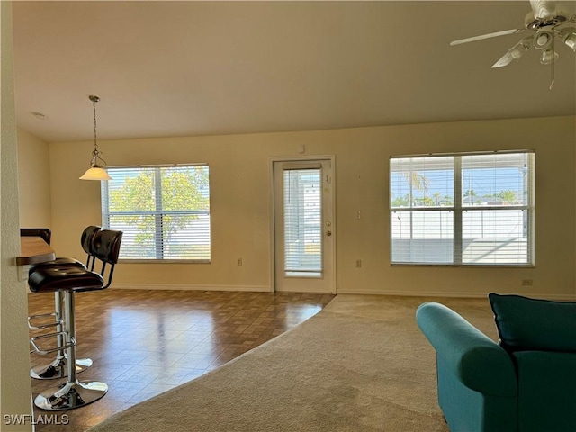 interior space with ceiling fan, baseboards, and carpet flooring