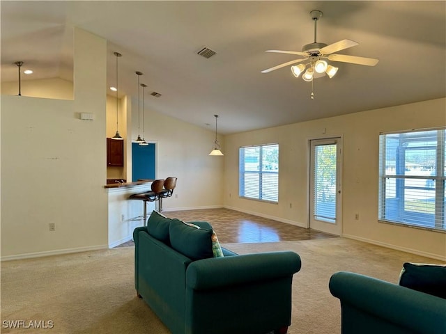 living room featuring lofted ceiling, light carpet, visible vents, and baseboards