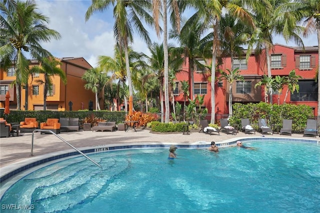 community pool featuring fence and a patio