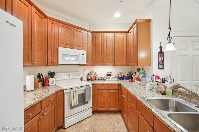 kitchen with light tile patterned floors, light stone counters, white appliances, a sink, and brown cabinetry