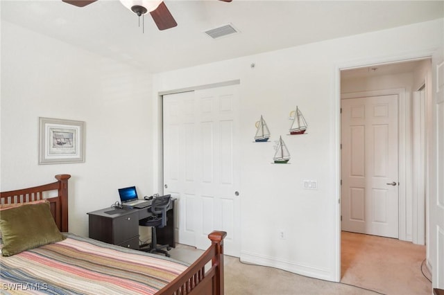 bedroom featuring a closet, light colored carpet, visible vents, ceiling fan, and baseboards