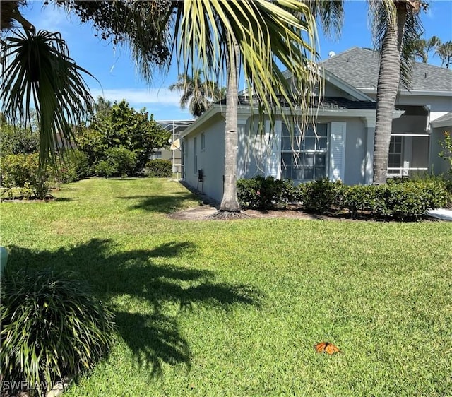 3650 Sunland Ln, Estero, FL 33928 - view of property exterior with roof with shingles, stucco siding, and a lawn