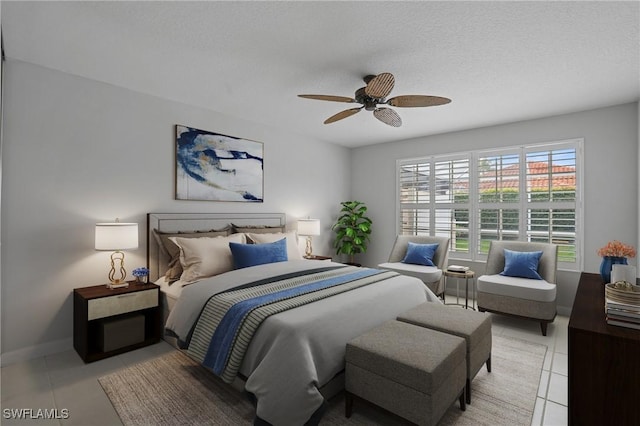 bedroom with light tile patterned floors, ceiling fan, baseboards, and a textured ceiling