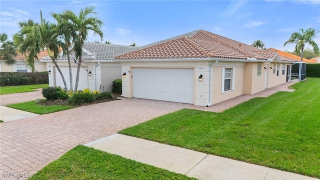 view of front facade featuring a front yard, decorative driveway, a tiled roof, and stucco siding