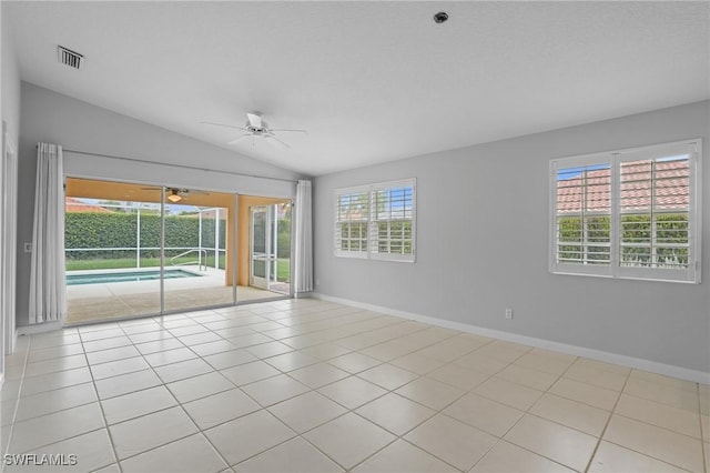 unfurnished room featuring baseboards, visible vents, a ceiling fan, lofted ceiling, and tile patterned flooring