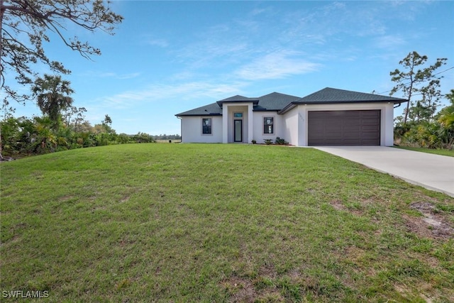 prairie-style house with a front yard, driveway, an attached garage, and stucco siding