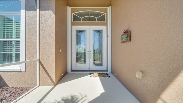 property entrance with french doors and stucco siding