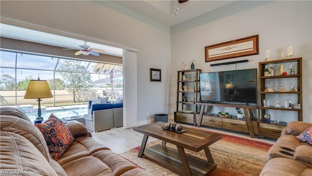 living area featuring ceiling fan, baseboards, and wood finished floors