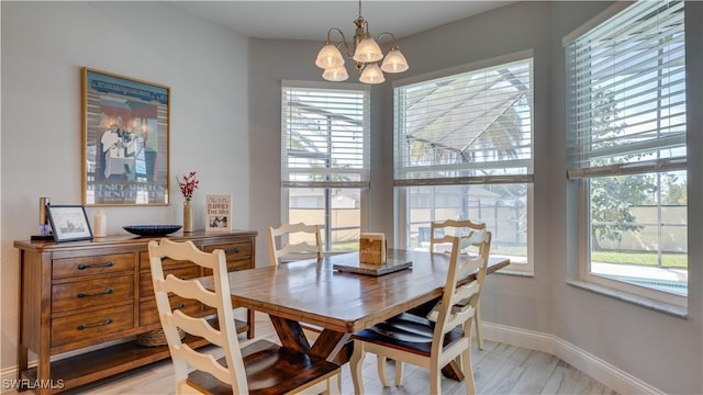 dining area with a chandelier, light wood-type flooring, and baseboards