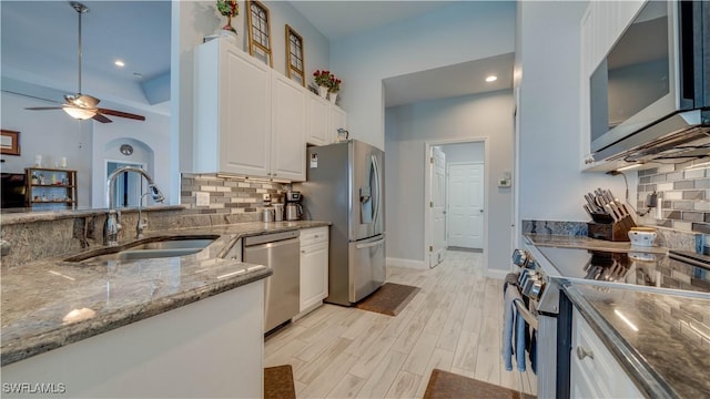 kitchen with white cabinetry, appliances with stainless steel finishes, decorative backsplash, and a sink