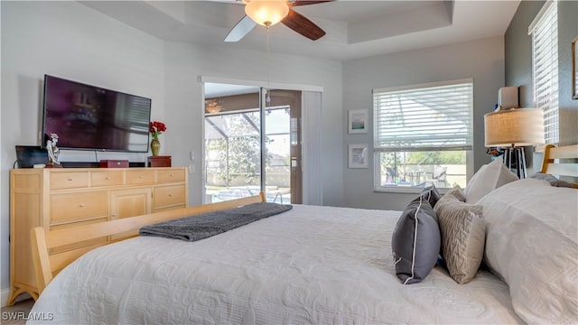 bedroom with a ceiling fan, access to outside, a sunroom, and multiple windows