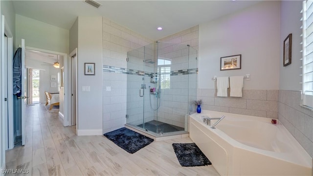 full bathroom featuring a garden tub, visible vents, a stall shower, wood finished floors, and baseboards