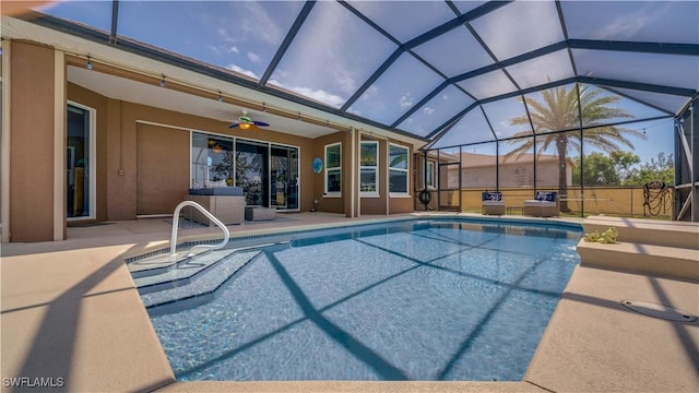 outdoor pool with a lanai, a patio area, and ceiling fan