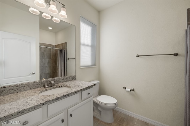 full bath with toilet, a tile shower, vanity, a chandelier, and baseboards