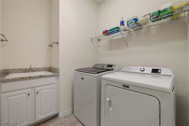 washroom with washer and dryer and a sink