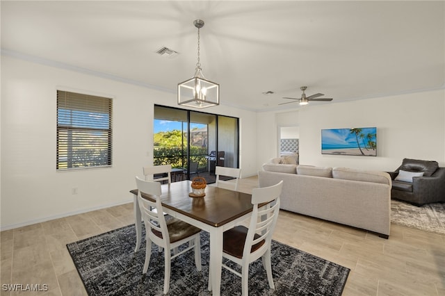 dining area with baseboards, ceiling fan with notable chandelier, visible vents, and ornamental molding