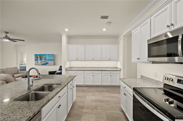 kitchen with stainless steel appliances, a sink, visible vents, white cabinets, and open floor plan