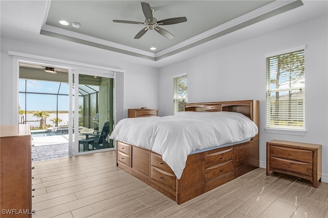 bedroom featuring access to outside, wood tiled floor, a raised ceiling, and crown molding