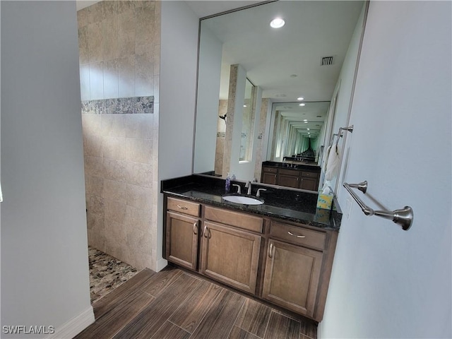 bathroom featuring recessed lighting, vanity, visible vents, wood tiled floor, and walk in shower