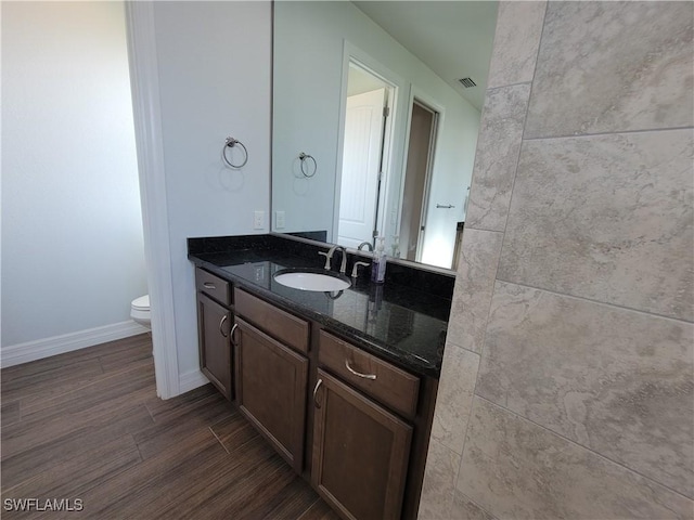 bathroom with visible vents, toilet, wood tiled floor, vanity, and baseboards