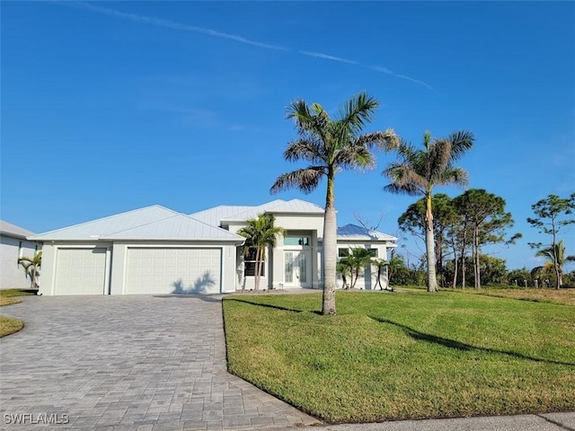 view of front of home featuring a front lawn, decorative driveway, an attached garage, and stucco siding