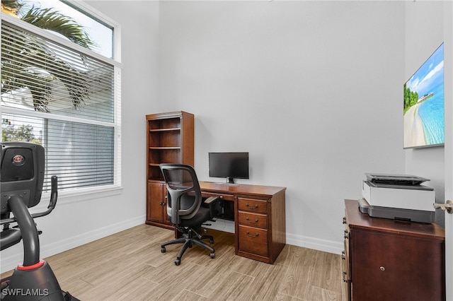 home office featuring baseboards and light wood finished floors