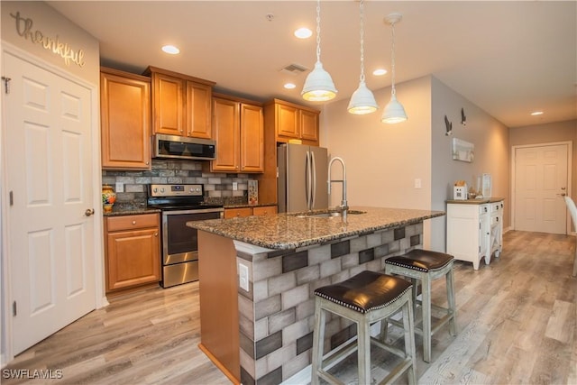 kitchen featuring appliances with stainless steel finishes, light wood-type flooring, visible vents, and tasteful backsplash