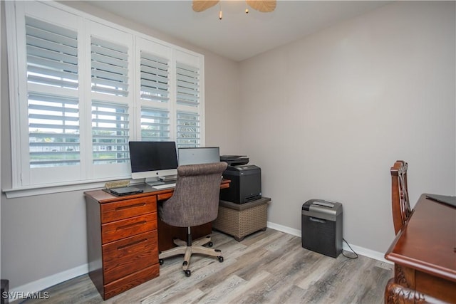 office space featuring a ceiling fan, light wood-style flooring, and baseboards