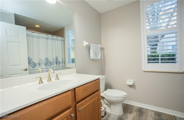 full bath featuring a wealth of natural light, vanity, toilet, and wood finished floors