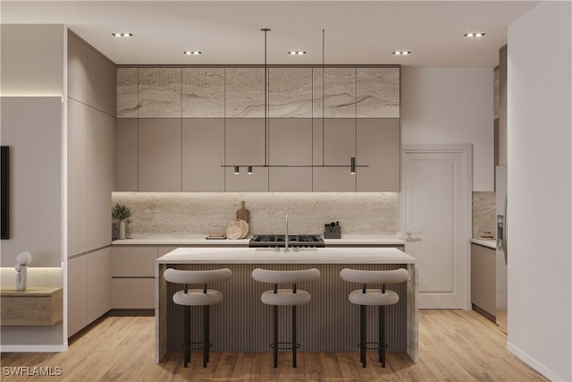 kitchen featuring light countertops, an island with sink, modern cabinets, and decorative backsplash