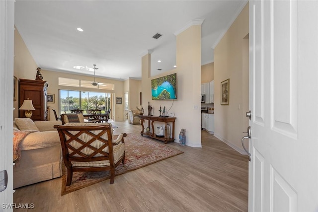 living room featuring recessed lighting, baseboards, visible vents, and light wood finished floors