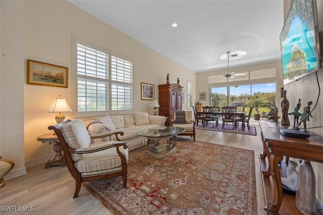 living area featuring baseboards, wood finished floors, and a ceiling fan