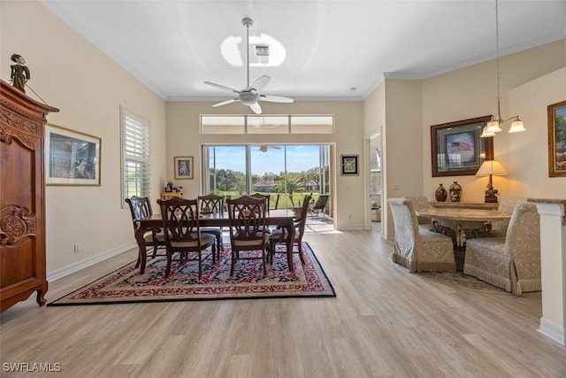 dining room featuring wood finished floors, baseboards, and ornamental molding