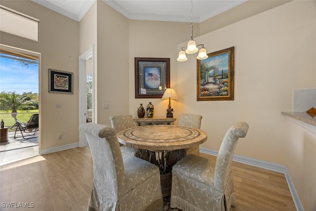 dining room with a chandelier, baseboards, wood finished floors, and ornamental molding