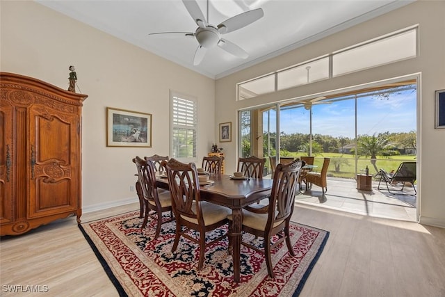 dining room with light wood-type flooring, baseboards, a ceiling fan, and crown molding