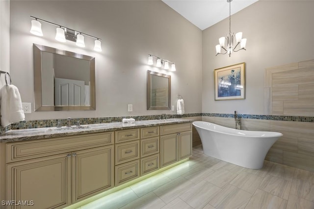 bathroom featuring a soaking tub, double vanity, tile walls, and a sink