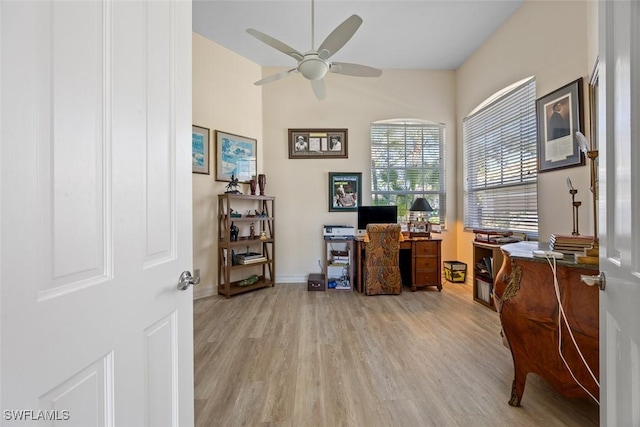 office area with baseboards, light wood-style floors, and ceiling fan