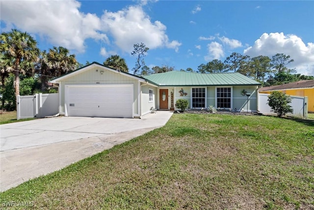 single story home with metal roof, fence, a garage, driveway, and a front lawn