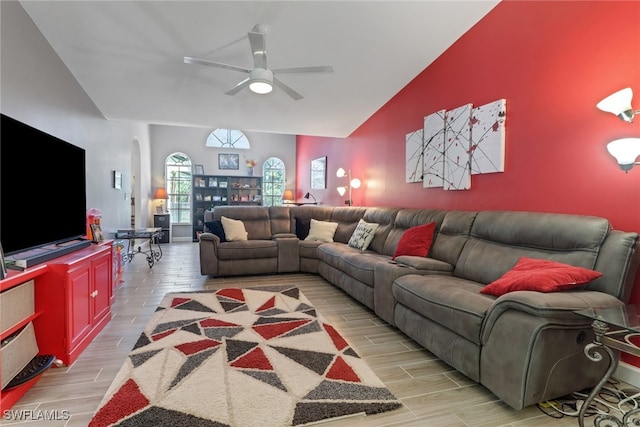 living area featuring wood tiled floor, arched walkways, vaulted ceiling, and a ceiling fan