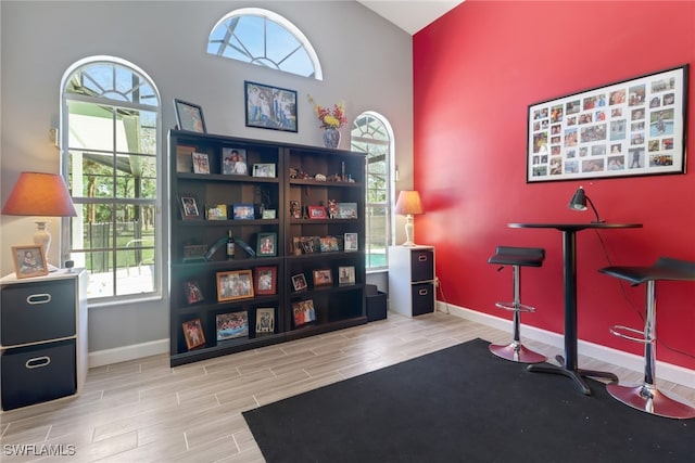 interior space with baseboards, lofted ceiling, and wood tiled floor