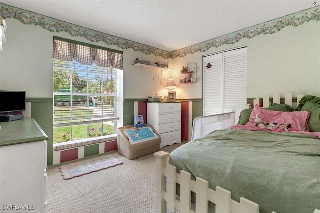 carpeted bedroom with a closet and a textured ceiling