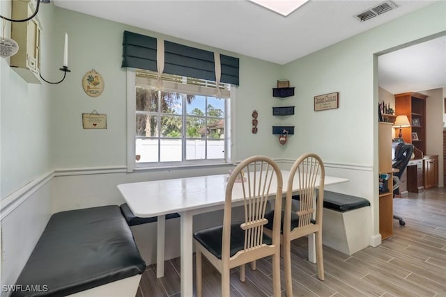 dining area with breakfast area, visible vents, and wood tiled floor