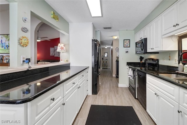 kitchen featuring a sink, white cabinetry, visible vents, wood tiled floor, and black appliances