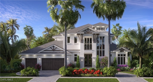 view of front of property with a garage, decorative driveway, a tile roof, and stucco siding