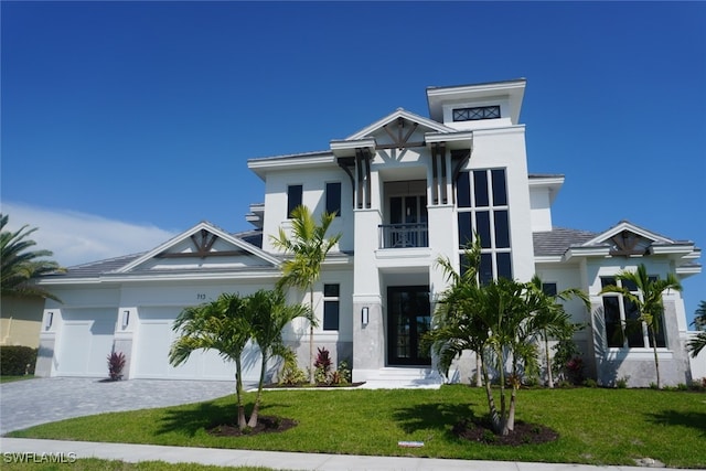 713 Nautilus Ct, Marco Island, FL 34145 - view of front of house featuring a balcony, a front yard, decorative driveway, and an attached garage